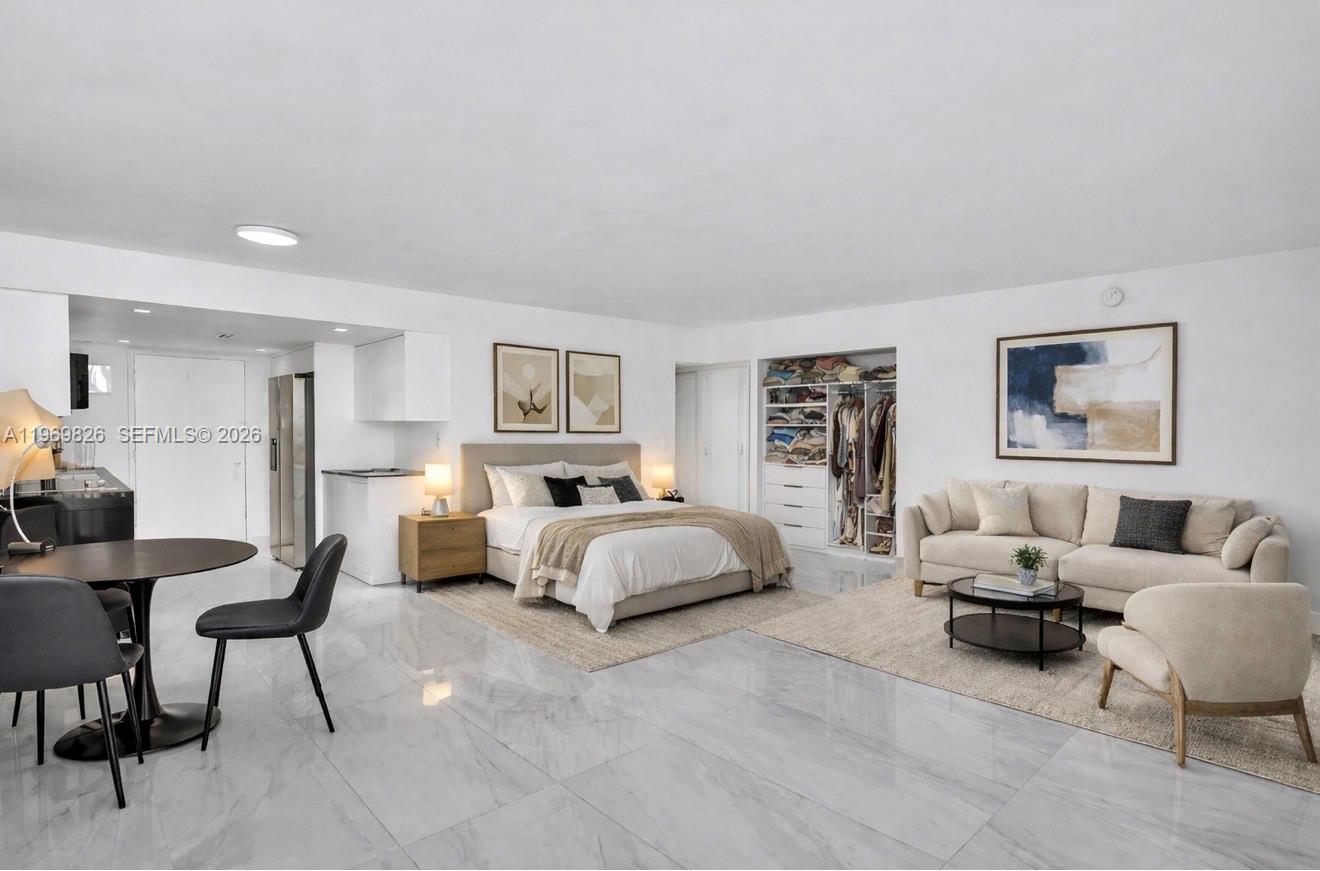 A studio apartment features a bed, sofa, dining area, and open kitchen with marble floors — 401 Ocean Dr # 1007, Miami Beach FL 33139, MIAMI BEACH, FL