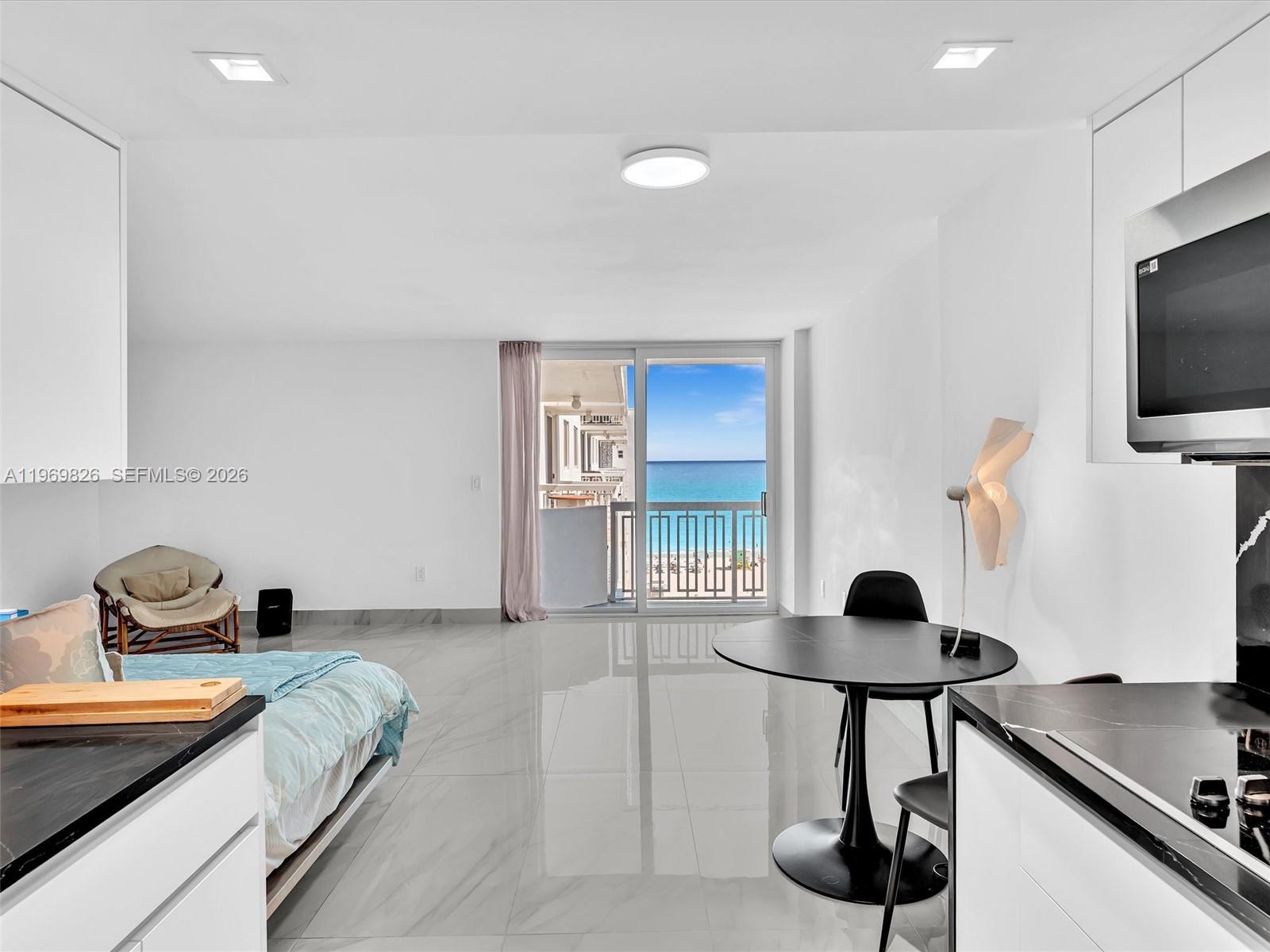 A studio apartment features white walls, marble-look tile flooring, a dining area, and ocean views — 401 Ocean Dr # 1007, Miami Beach FL 33139, MIAMI BEACH, FL