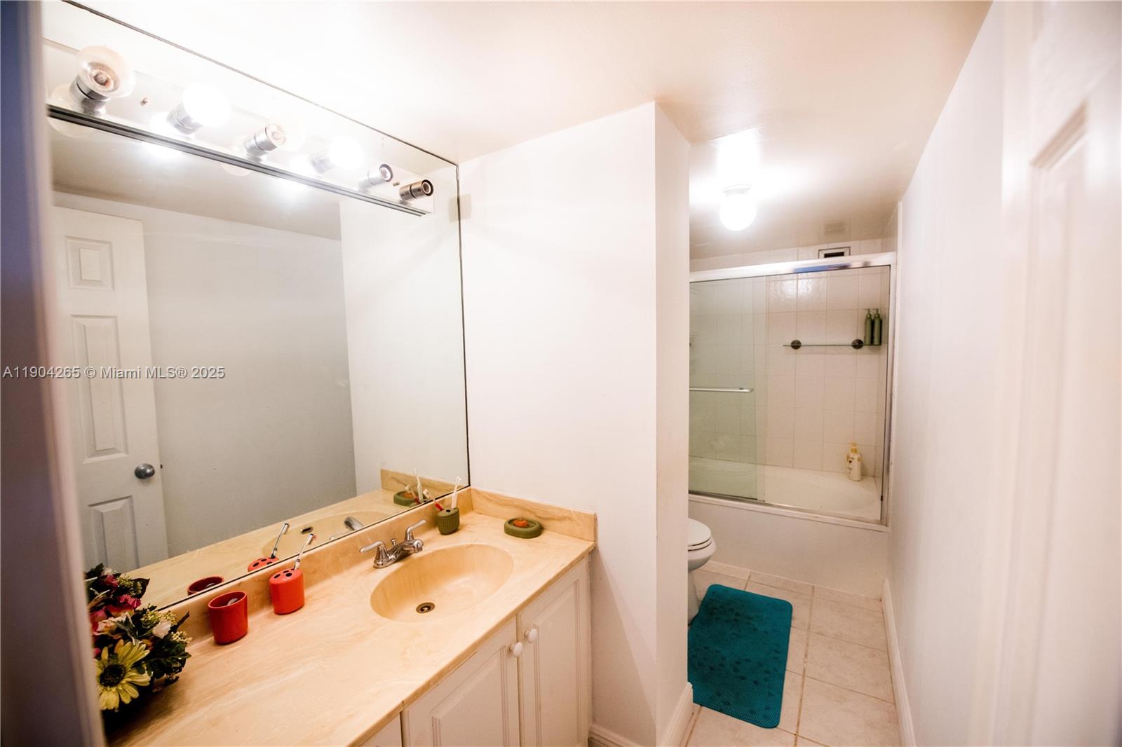 A bathroom features a vanity with a light-colored countertop, a large mirror, and a tub-shower — 200 Leslie Dr # 214, Hallandale Beach FL 33009, HALLANDALE BEACH, FL