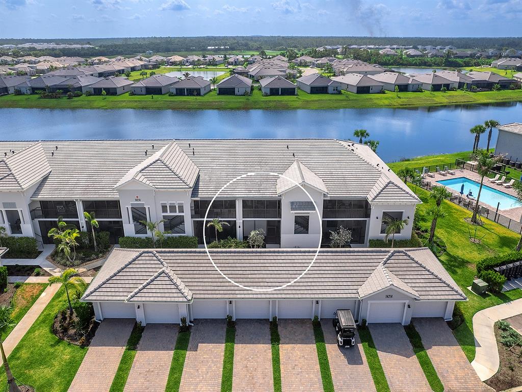 An aerial view shows a multi-unit residential building with a tiled roof and attached garages — 14214 HERITAGE LANDING BOULEVARD UNIT 817, PUNTA GORDA, FL