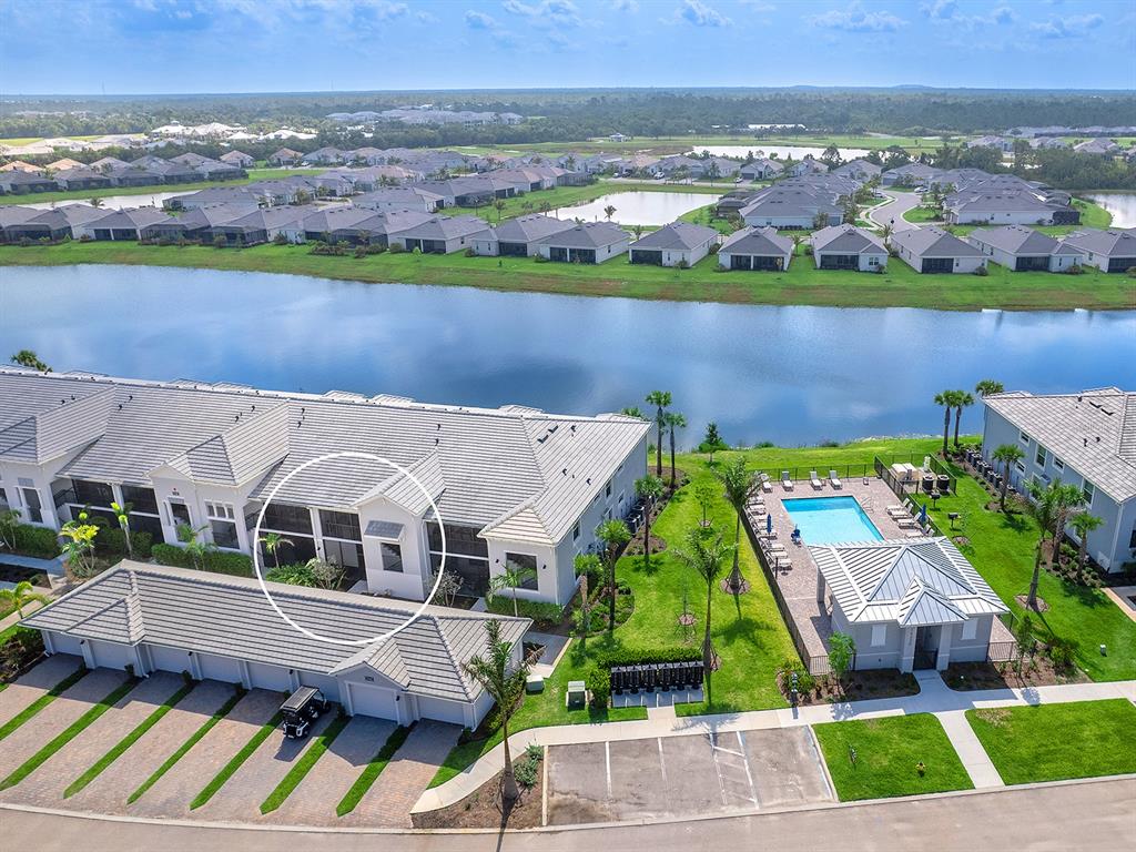 An aerial view shows a multi-unit residential building with a pool and a lake — 14214 HERITAGE LANDING BOULEVARD UNIT 817, PUNTA GORDA, FL