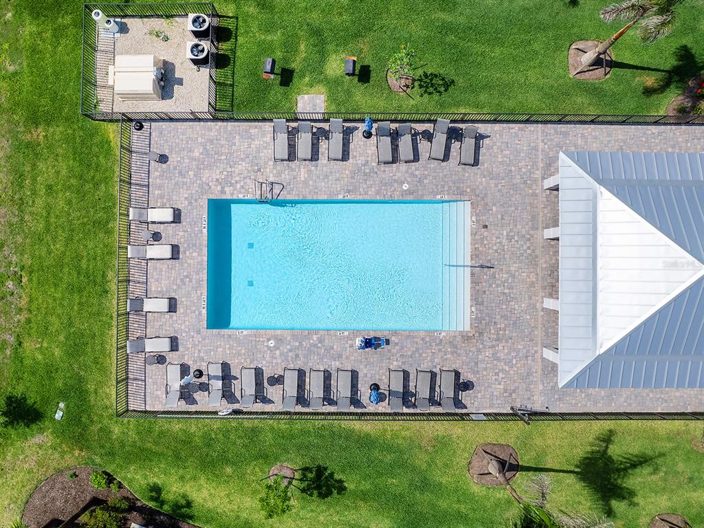 An aerial view shows a rectangular swimming pool surrounded by a paved deck and lounge chairs — 14214 HERITAGE LANDING BOULEVARD UNIT 817, PUNTA GORDA, FL