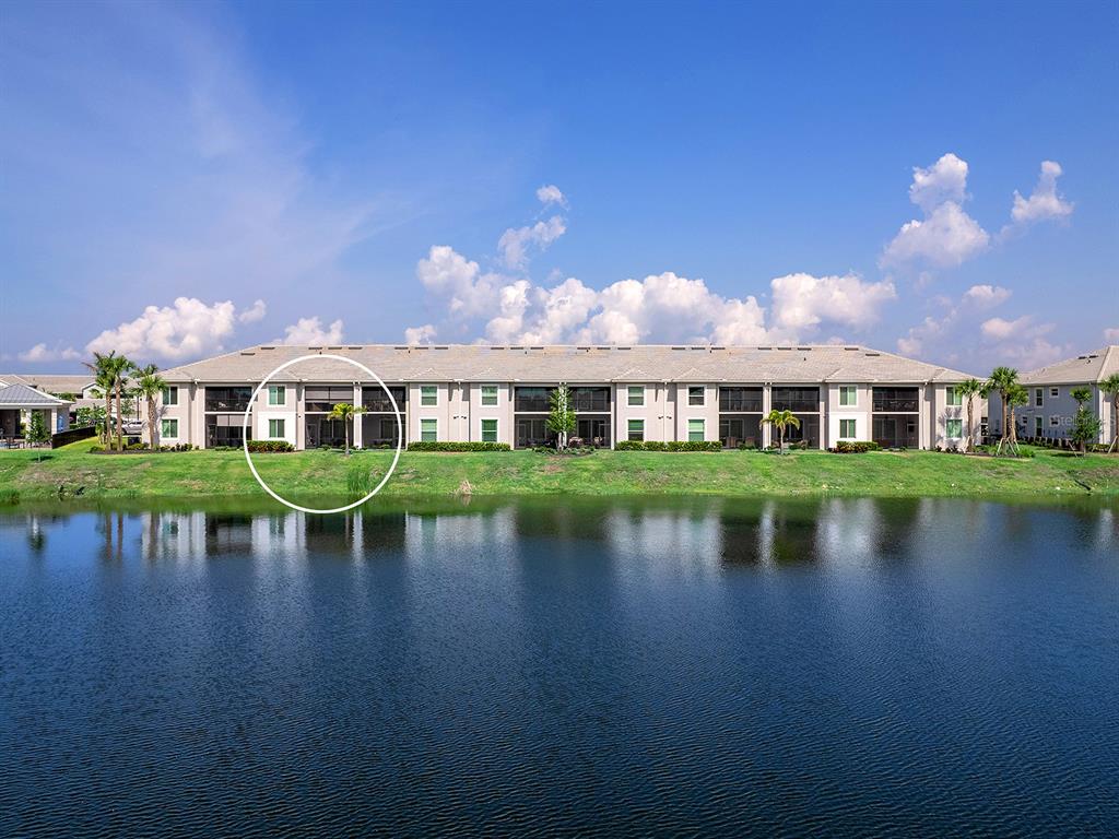 A multi-story apartment building with screened-in lanais sits along the edge of a lake — 14214 HERITAGE LANDING BOULEVARD UNIT 817, PUNTA GORDA, FL