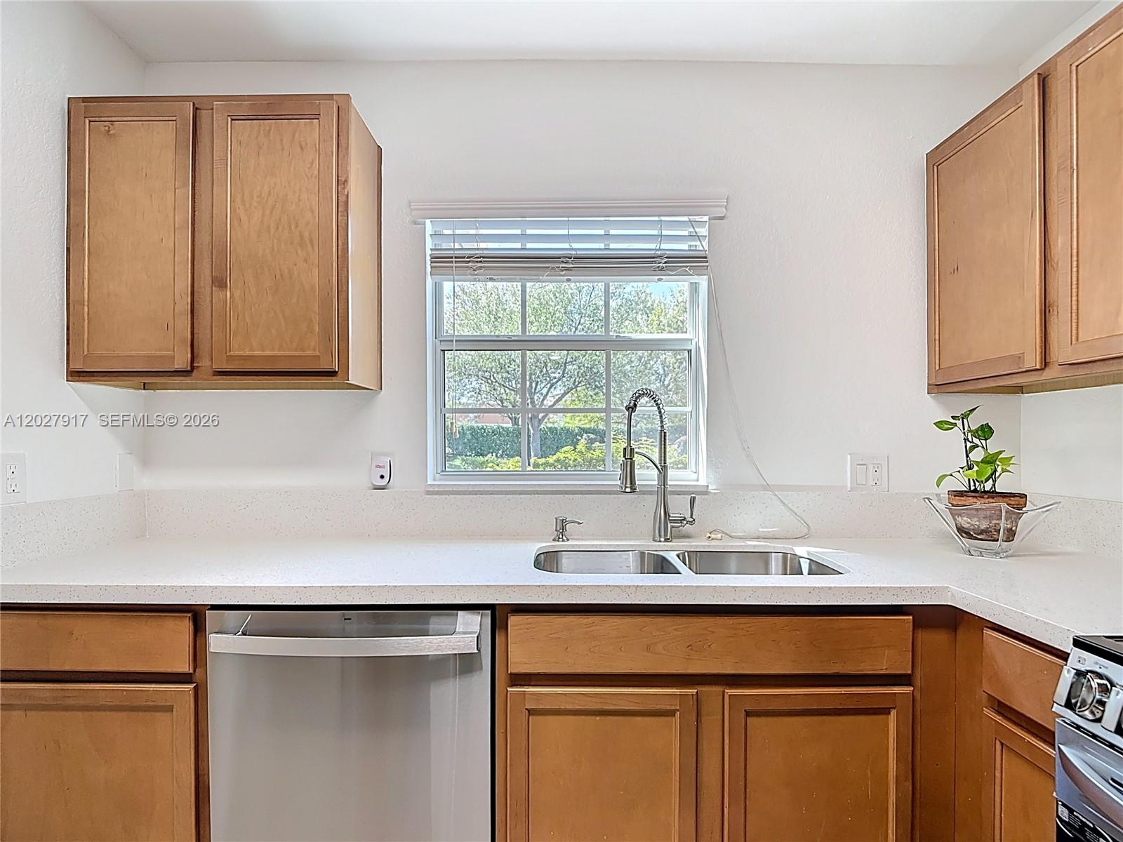 A kitchen features wood cabinets, a white countertop, a stainless steel sink, and a window — 9101 GERVAIS # 1705, Naples FL 34120, NAPLES, FL