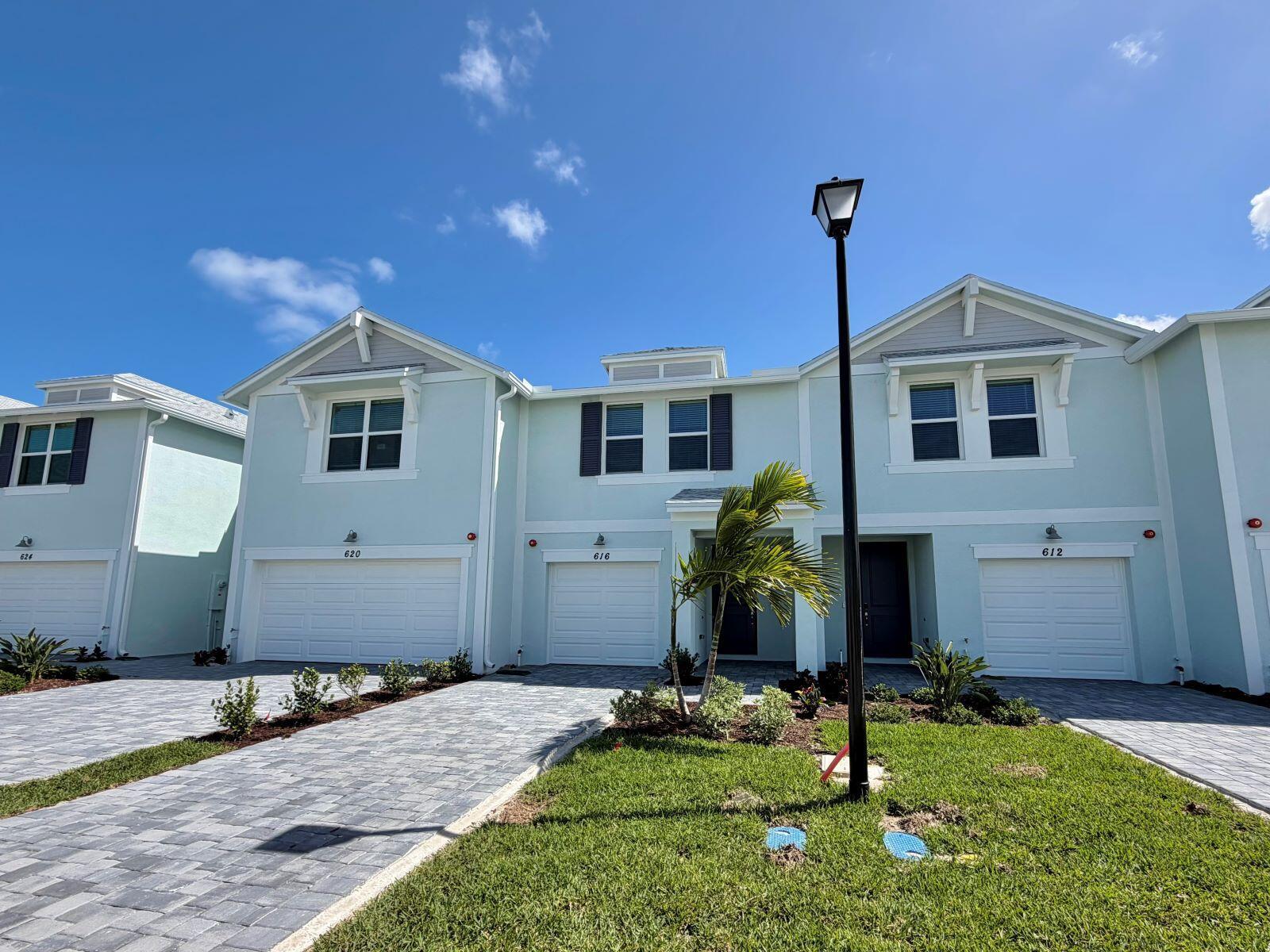A light blue two-story townhouse with a white garage door and a paved driveway — 632 Salisbury Circle, Fort Pierce FL 34982, FORT PIERCE, FL