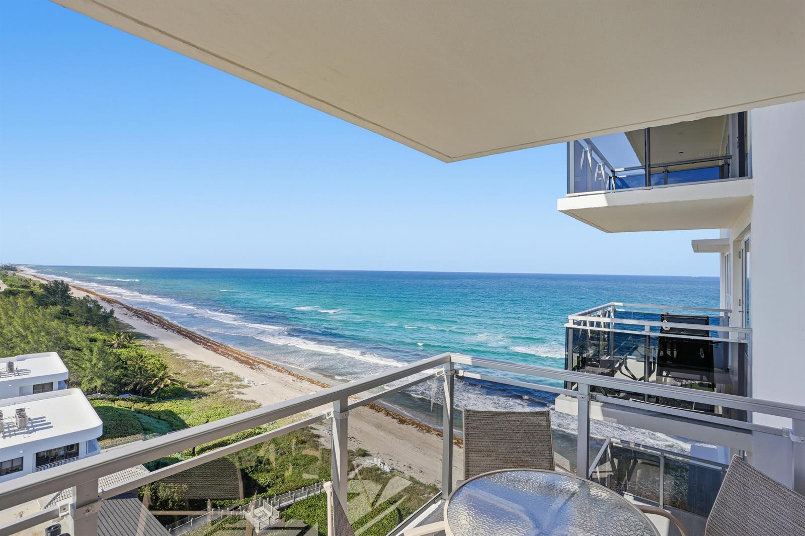 A high-rise balcony overlooks a sandy beach and the ocean on a sunny day — 2066 N Ocean Boulevard, Boca Raton FL 33431, BOCA RATON, FL