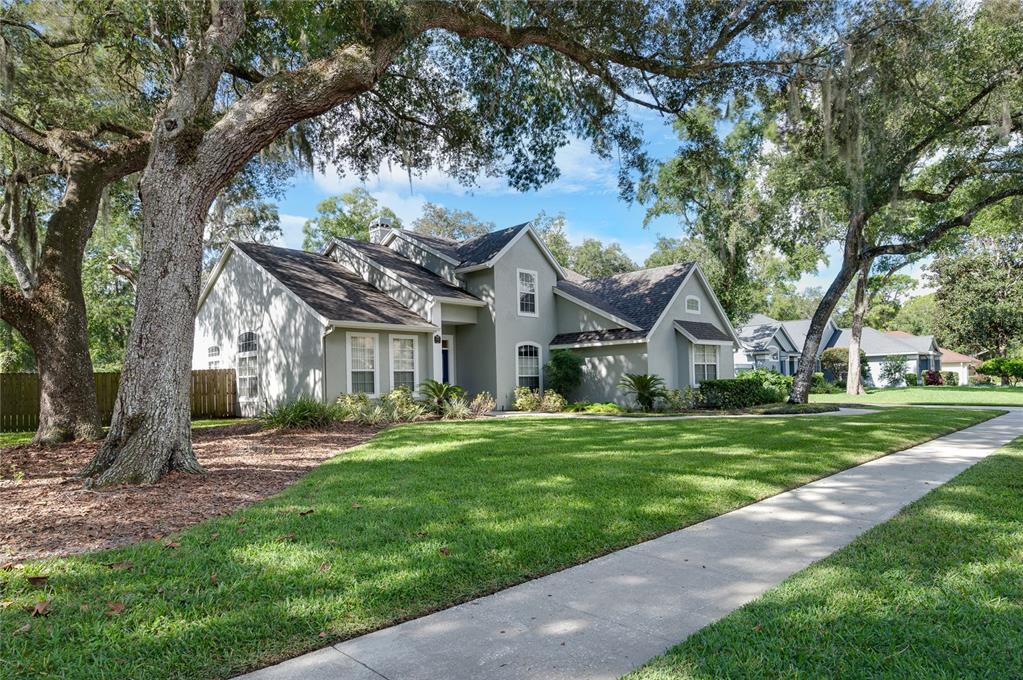 A two-story house with a gray exterior, a shingled roof, and large oak trees — 5091 GREAT OAK LANE, SANFORD, FL