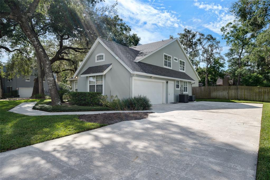 A two-story house with a light green exterior, a two-car garage, and a concrete driveway — 5091 GREAT OAK LANE, SANFORD, FL