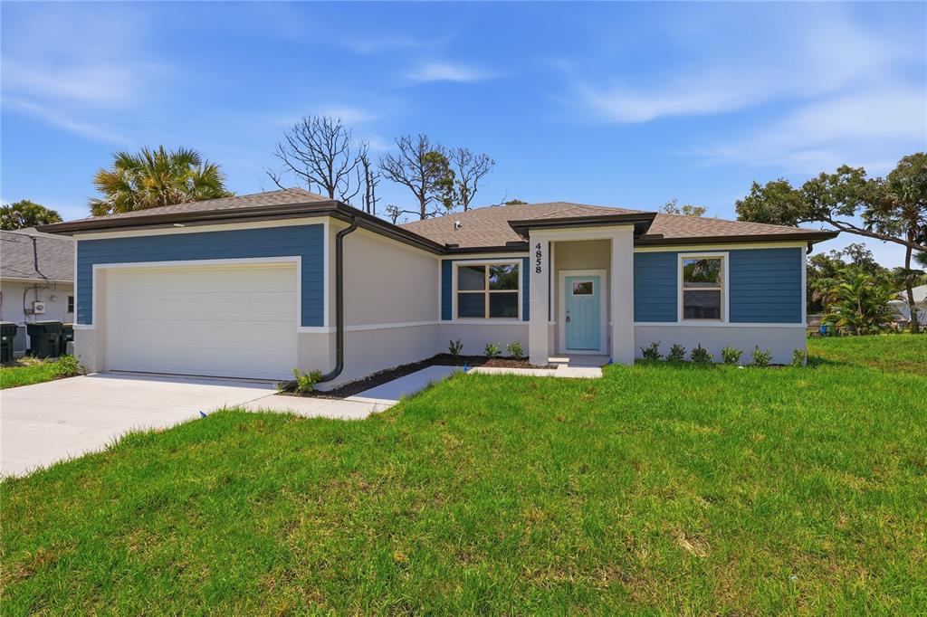 A single-story house with blue siding, a white garage, and a light blue front door — 4858 FLINT DRIVE, NORTH PORT, FL