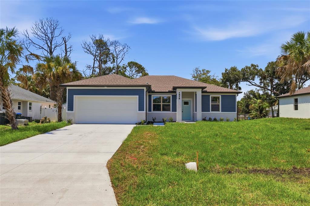 A single-story house with blue siding, a white garage door, and a light blue front door — 4858 FLINT DRIVE, NORTH PORT, FL