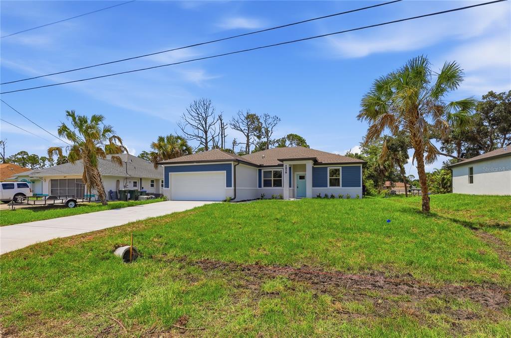 A single-story house with a blue-accented exterior, a two-car garage, and a front lawn — 4858 FLINT DRIVE, NORTH PORT, FL
