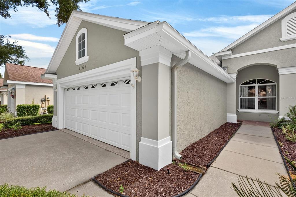 A view of a house exterior featuring a two-car garage, a walkway, and stucco siding — 3167 KAILANI COURT, ORMOND BEACH, FL