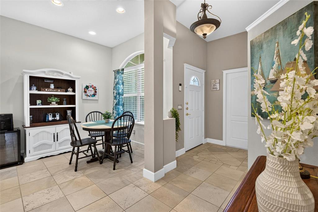 A dining area with a hutch and table sits beside an entryway with tiled floors — 3167 KAILANI COURT, ORMOND BEACH, FL