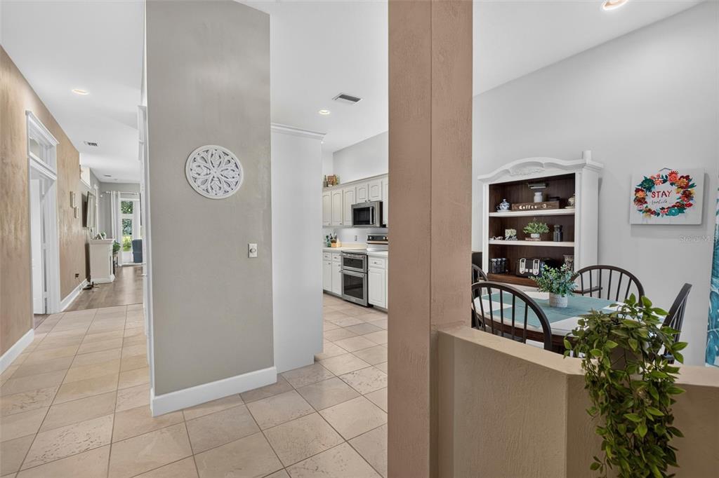A view from a dining area looking toward a kitchen with white cabinets — 3167 KAILANI COURT, ORMOND BEACH, FL