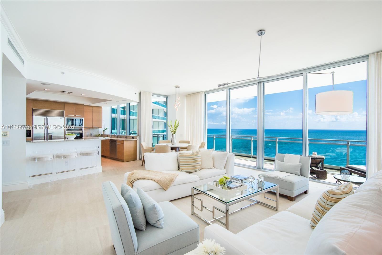 A bright living room and kitchen area features floor-to-ceiling windows overlooking the ocean — 10295 Collins Ave # 1202, Bal Harbour FL 33154, BAL HARBOUR, FL