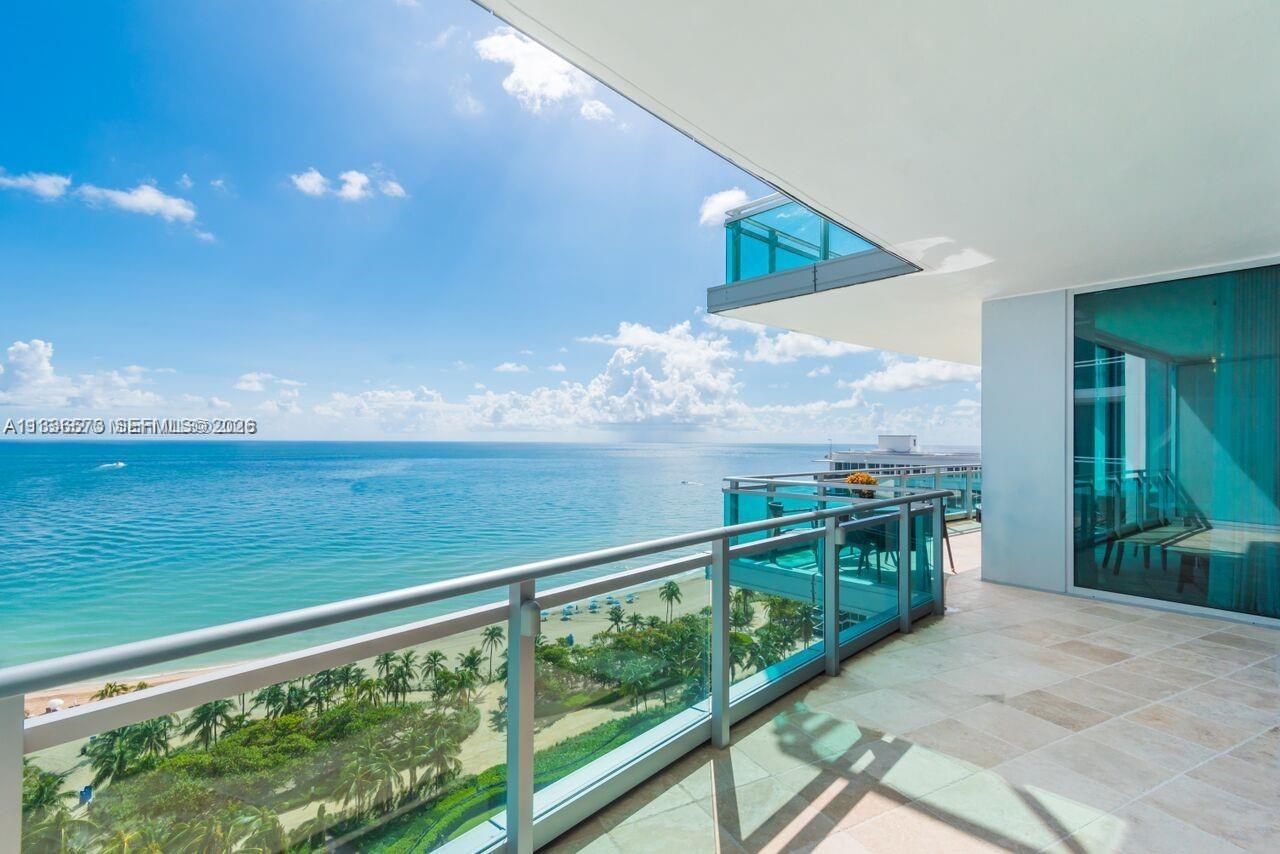 A high-rise balcony features glass railings, stone flooring, and a panoramic view of the ocean — 10295 Collins Ave # 1202, Bal Harbour FL 33154, BAL HARBOUR, FL