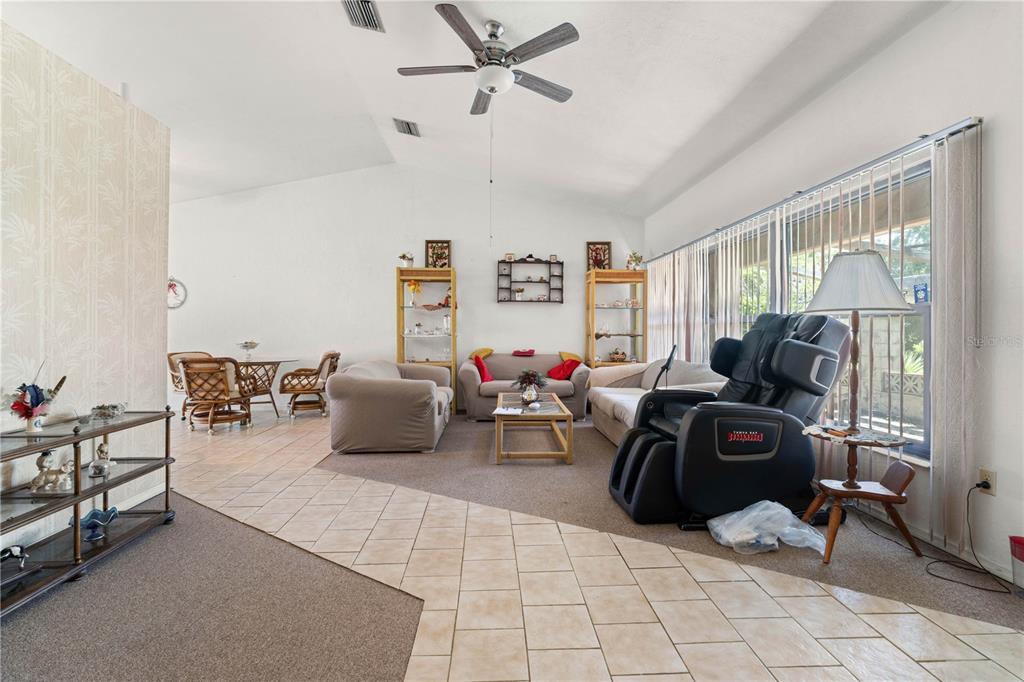 A living room with tile and carpet flooring, a ceiling fan, and a massage chair — 2065 DUNCAN ROAD, PUNTA GORDA, FL