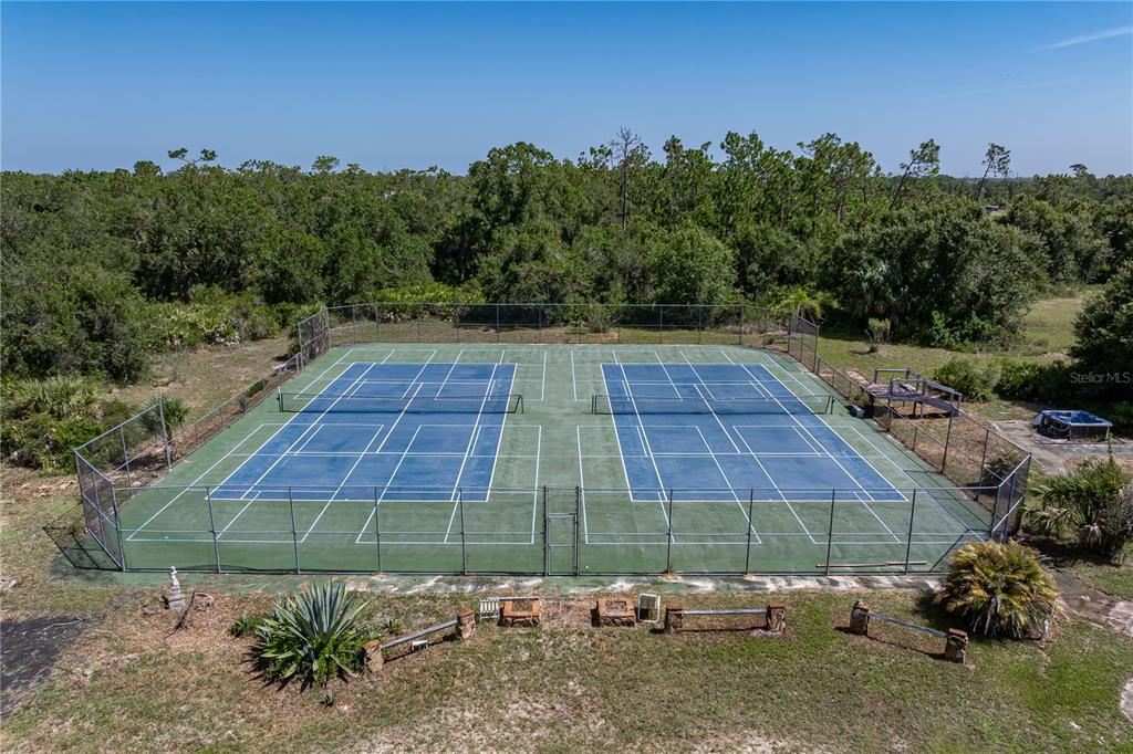 An aerial view of two outdoor tennis courts enclosed by a chain-link fence — 2065 DUNCAN ROAD, PUNTA GORDA, FL