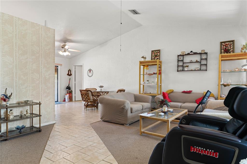 A living room with tile and carpet flooring, two sofas, a coffee table, and a recliner — 2065 DUNCAN ROAD, PUNTA GORDA, FL