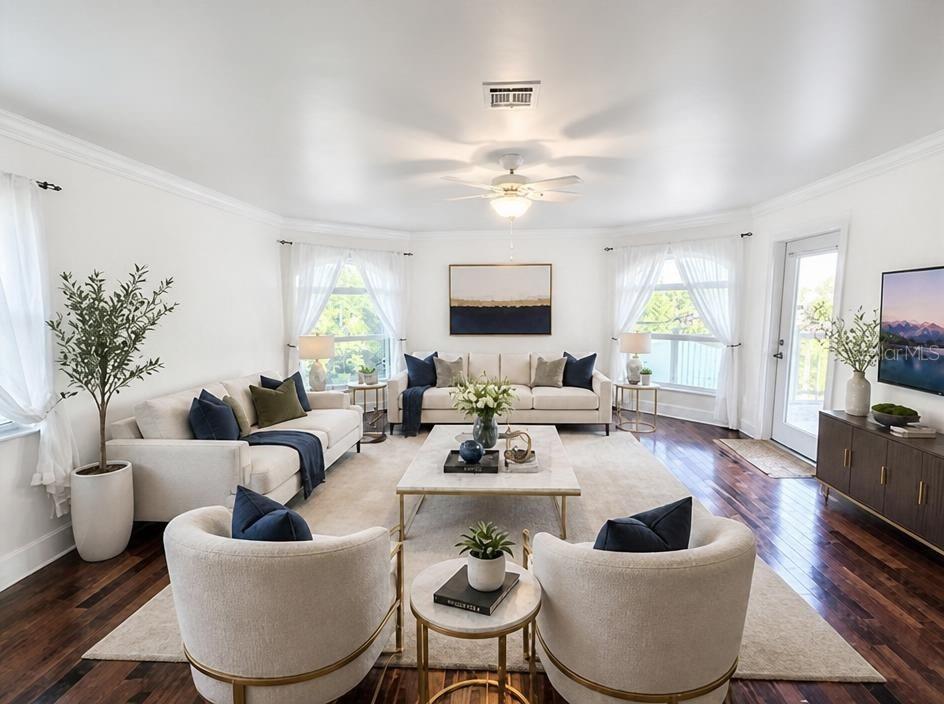 A bright living room features two beige sofas, two armchairs, a coffee table, and hardwood floors — 1343 UNDERHILL CIRCLE, PORT CHARLOTTE, FL
