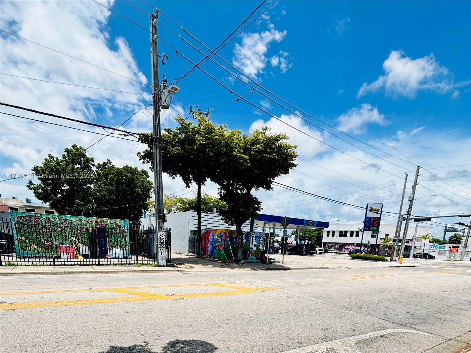 A street-level view shows a gas station with colorful murals, a utility pole, and power lines — 203 NW 35th St, Miami FL 33127, MIAMI, FL