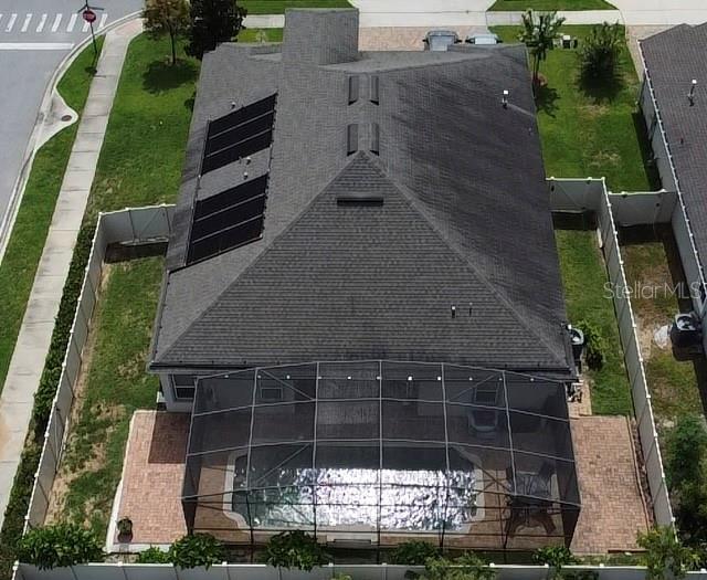 An aerial view of a house with a screened-in pool, patio, and roof solar panels — 2504 CAVENDER CREEK ROAD, MINNEOLA, FL