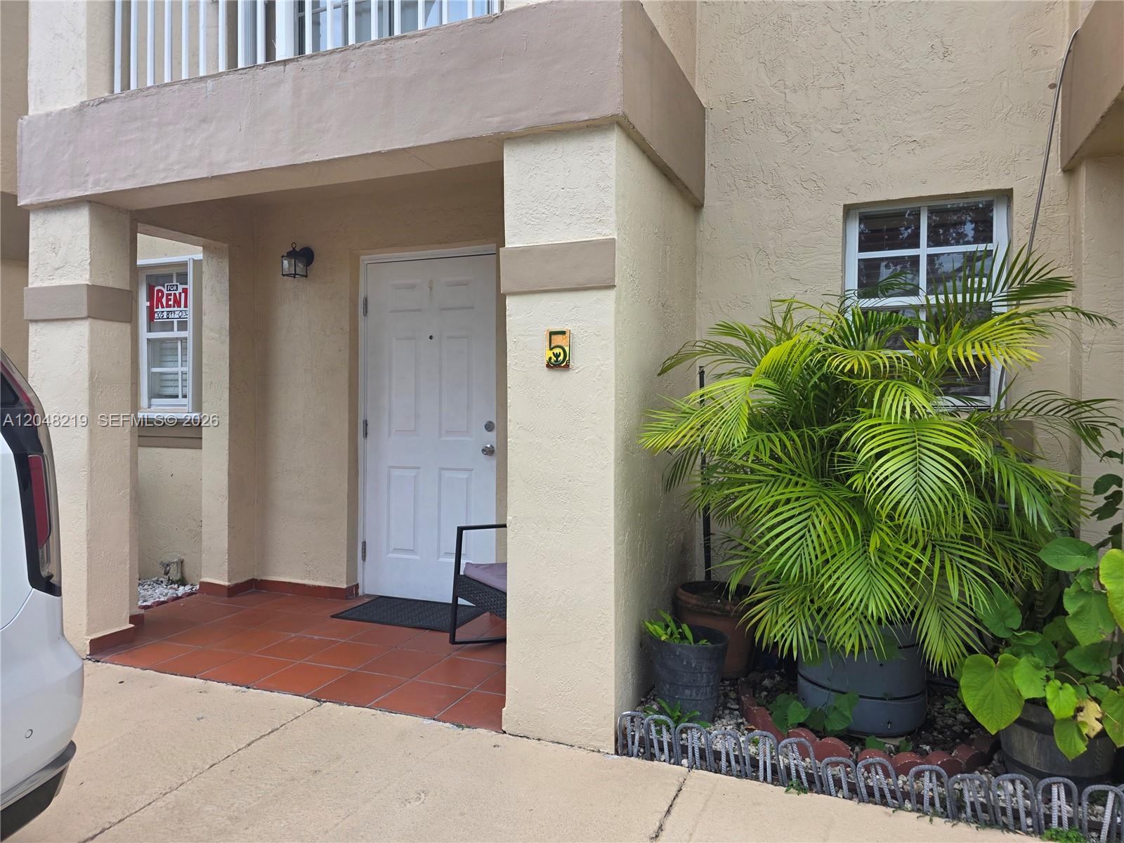 A white front door with a number five sign sits under a covered entryway — 523 W 68th St # 5, Hialeah FL 33014, HIALEAH, FL