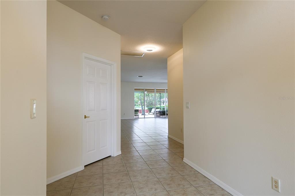 A tiled entryway leads into a living area with sliding glass doors opening to a patio — 18014 JAVA ISLE DRIVE, TAMPA, FL