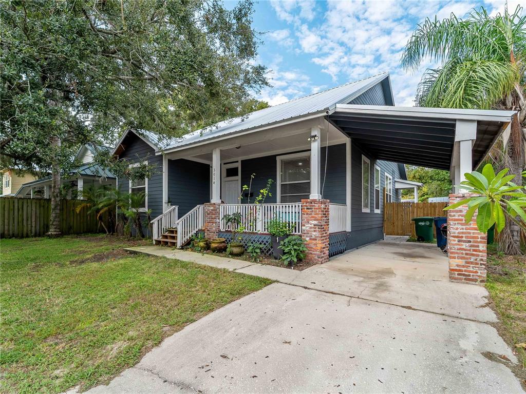 A dark blue bungalow with a front porch, metal roof, and attached carport — 3014 N TAMPA STREET, TAMPA, FL
