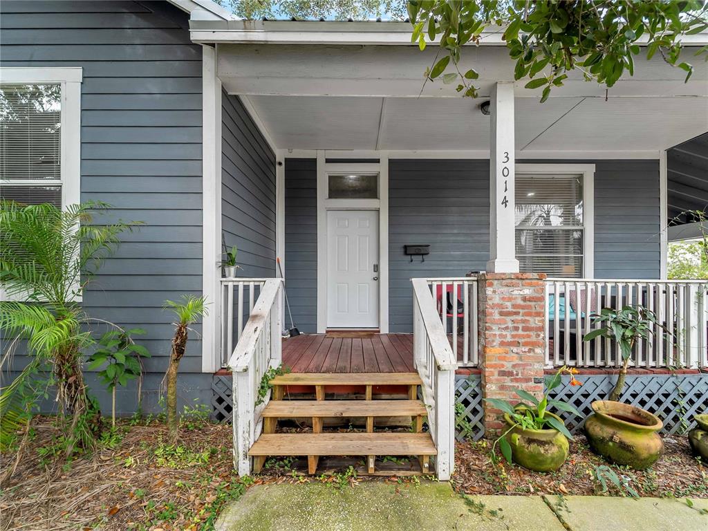 A front porch with wooden steps, white railings, and a blue-gray exterior wall — 3014 N TAMPA STREET, TAMPA, FL