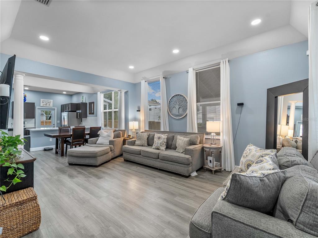 A living room with gray flooring, a sectional sofa, and an open-concept kitchen area — 3014 N TAMPA STREET, TAMPA, FL
