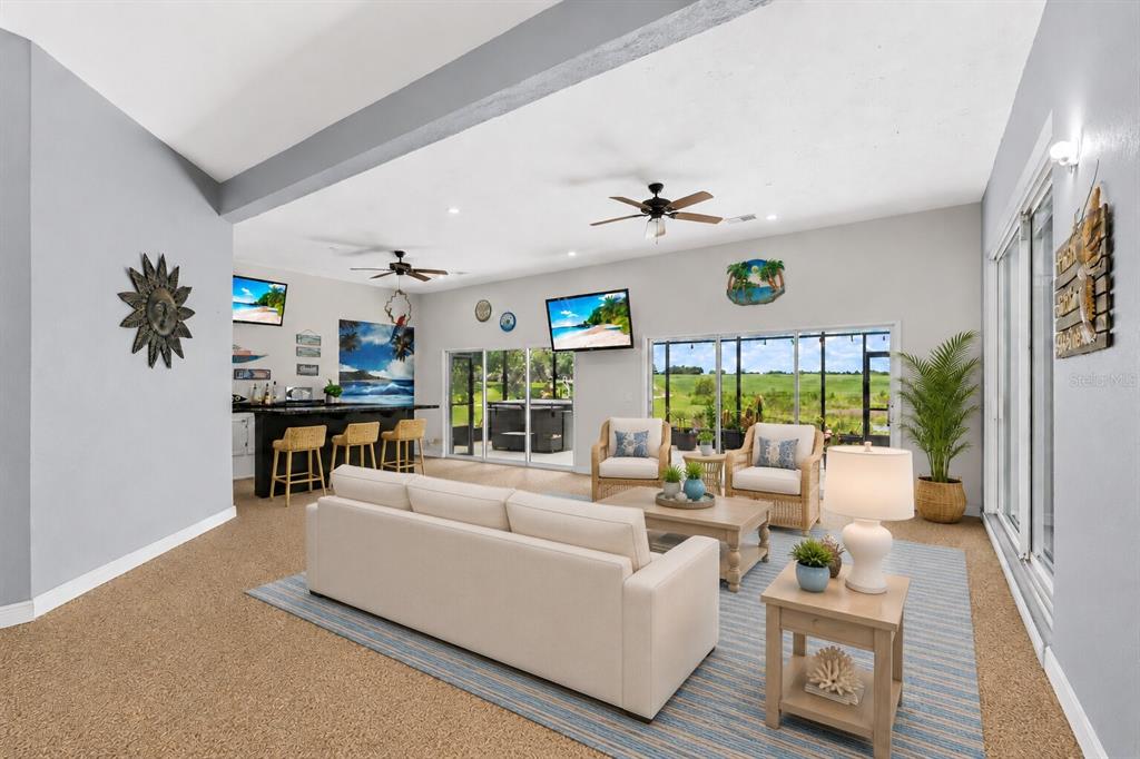 A living room with a bar, seating area, and sliding glass doors overlooking a field — 25501 MAUREPAS LANE, LEESBURG, FL