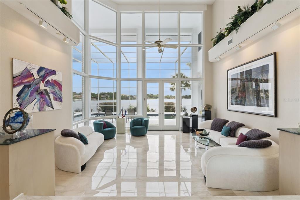 An aerial view shows a large waterfront house with a pool on a peninsula — 315 MENASHE COURT, LONGWOOD, FL
