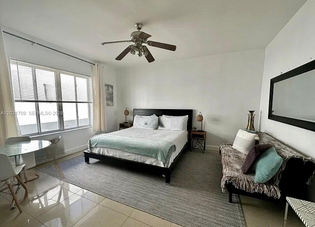 A bedroom features a bed, a small sofa, a dining table, and a ceiling fan — 3700 Collins Ave # 306, Miami Beach FL 33140, MIAMI BEACH, FL