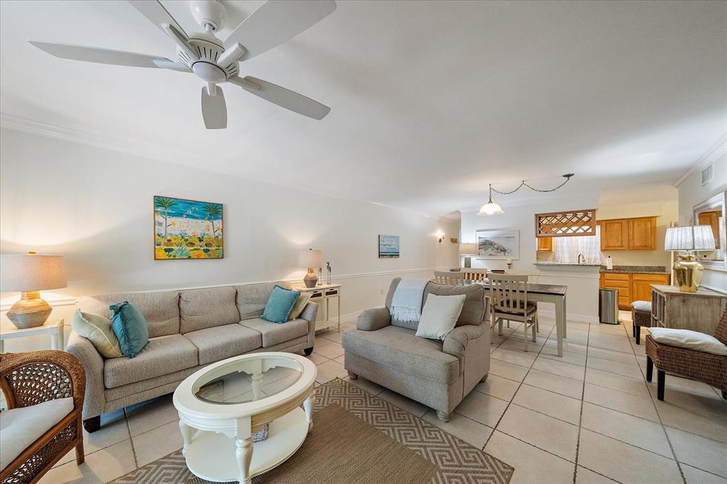 A living room with a sofa, armchair, dining area, and tile flooring under a ceiling fan — 3360 S OSPREY AVENUE UNIT 104B, SARASOTA, FL