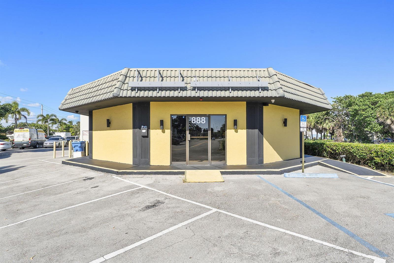 A yellow, single-story commercial building with a gray tiled roof and a glass entrance — 888 E Coast Avenue, Lantana FL 33462, LANTANA, FL