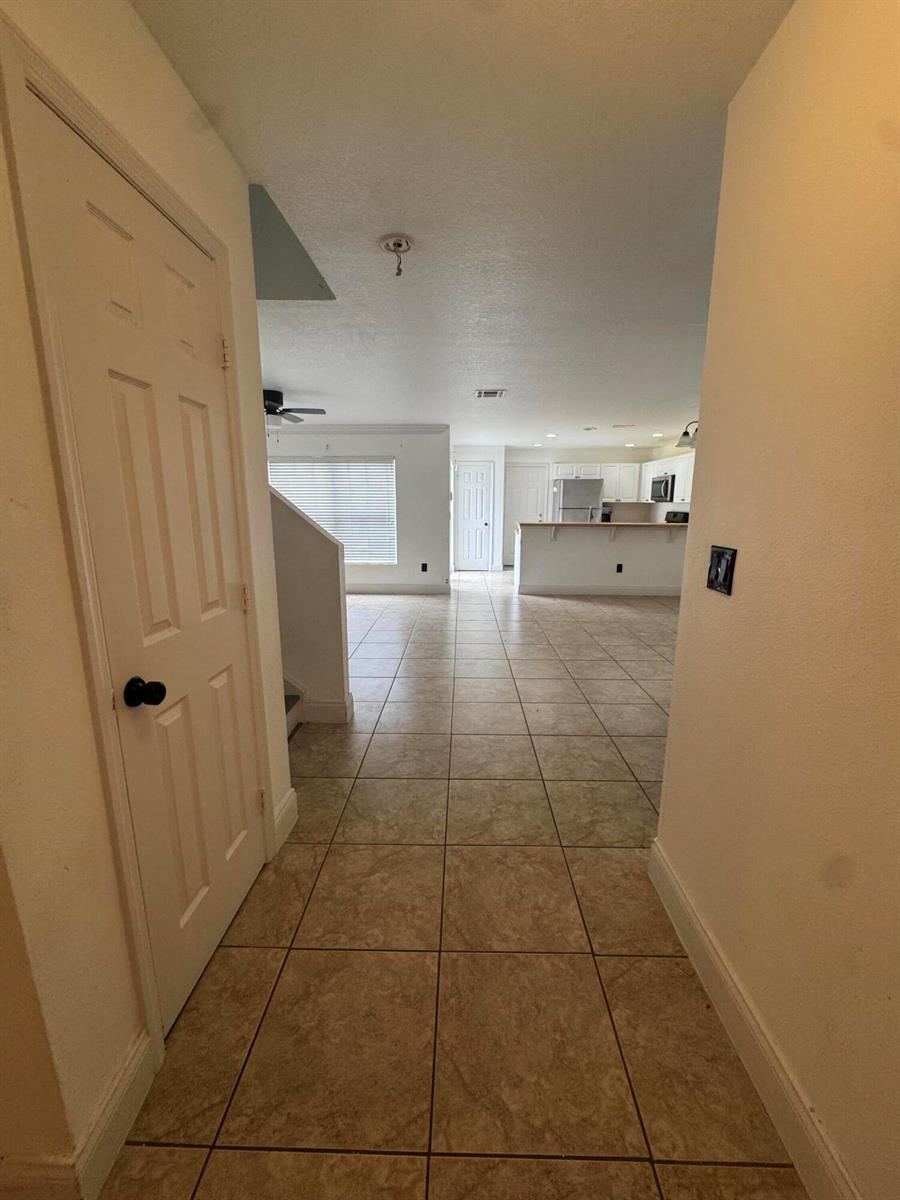A tiled hallway leads from a doorway toward an open-concept living area and kitchen — 1733 Pointe West Way, Vero Beach FL 32966, VERO BEACH, FL