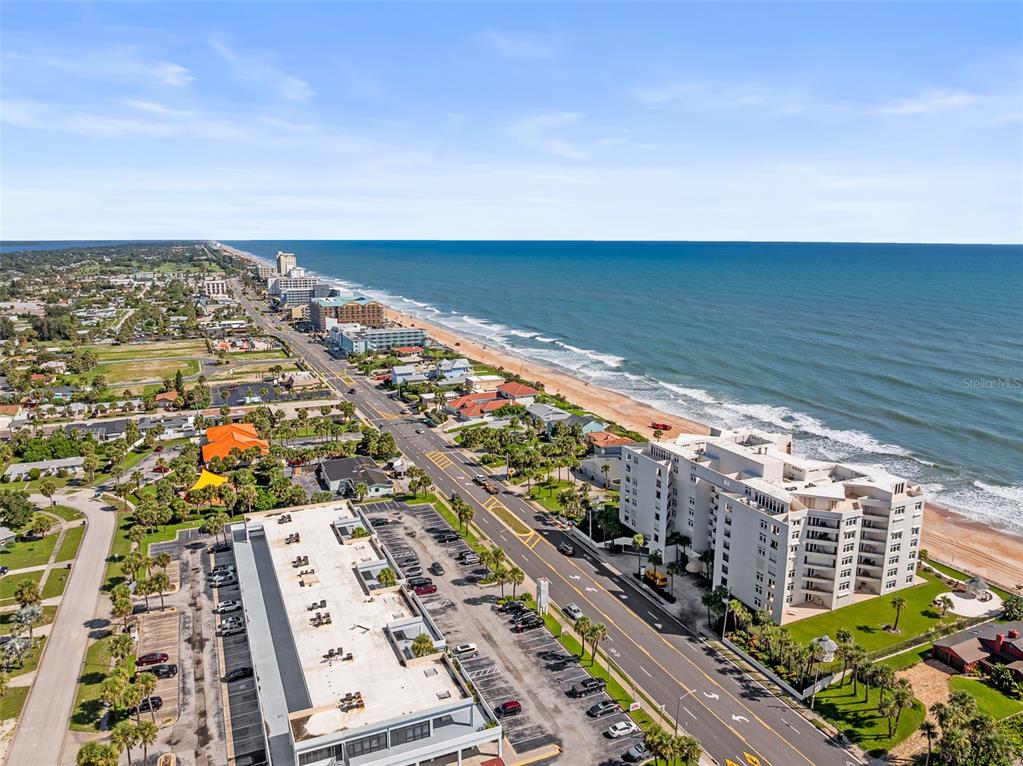 An aerial view shows a coastal road running parallel to the beach and ocean — 395 S ATLANTIC AVENUE UNIT 102, ORMOND BEACH, FL