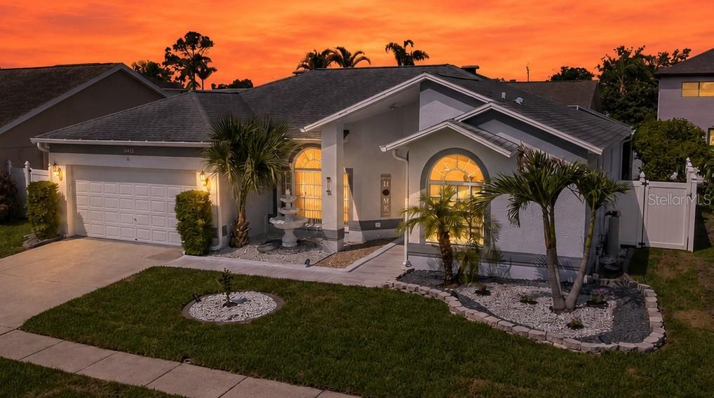 A single-story house with a white garage, arched windows, and palm trees in the front yard — 11426 ZENITH CIRCLE, TAMPA, FL