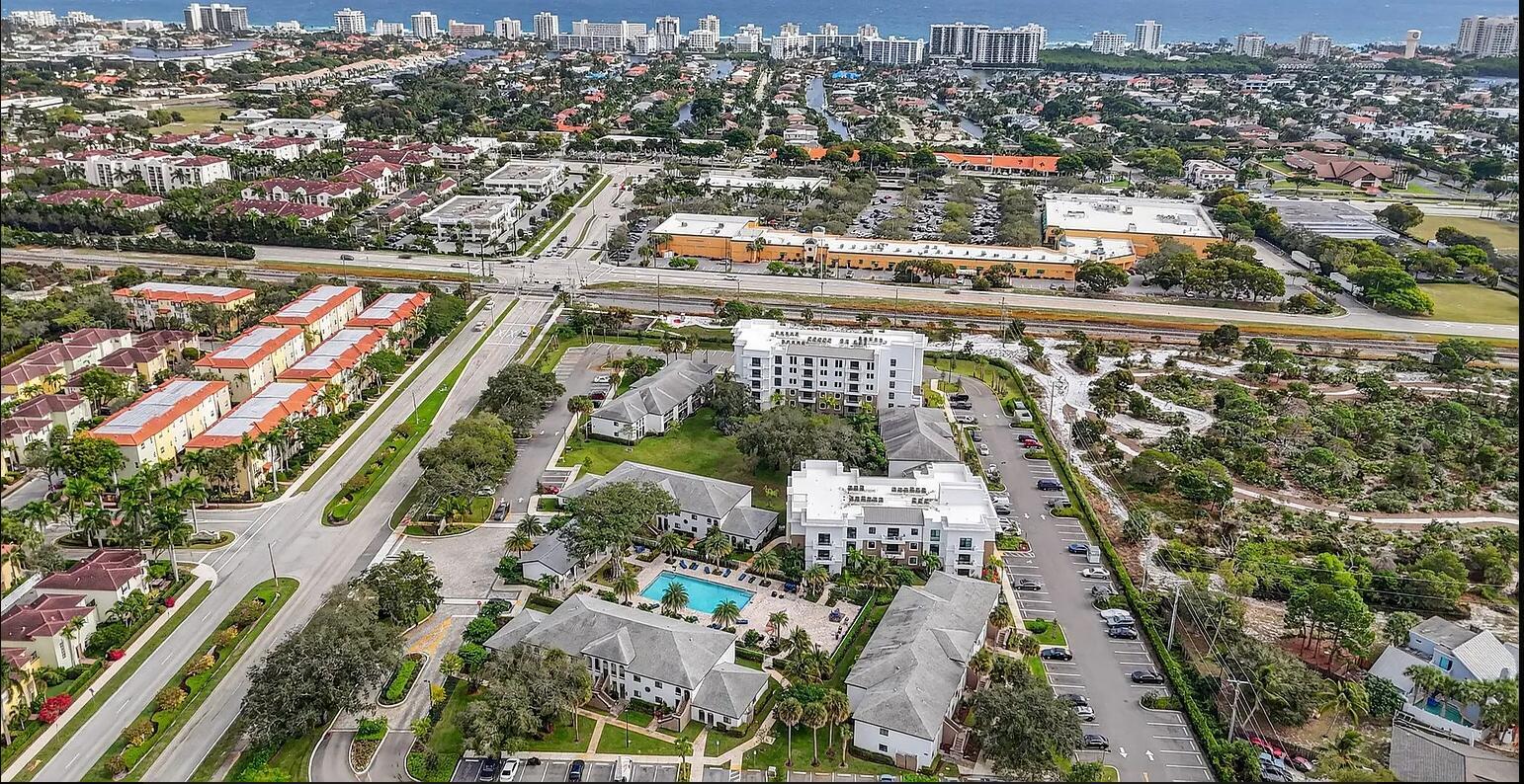 Aerial view of a multi-building apartment complex with a swimming pool and surrounding parking lots — 100 W Hidden Valley Boulevard # 302, Boca Raton FL 33487, BOCA RATON, FL