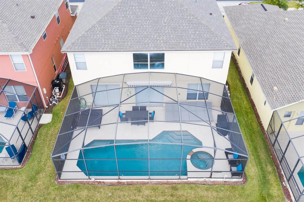 An aerial view shows a house with a screened-in pool, spa, and patio area — 182 HIDEAWAY BEACH LANE, KISSIMMEE, FL