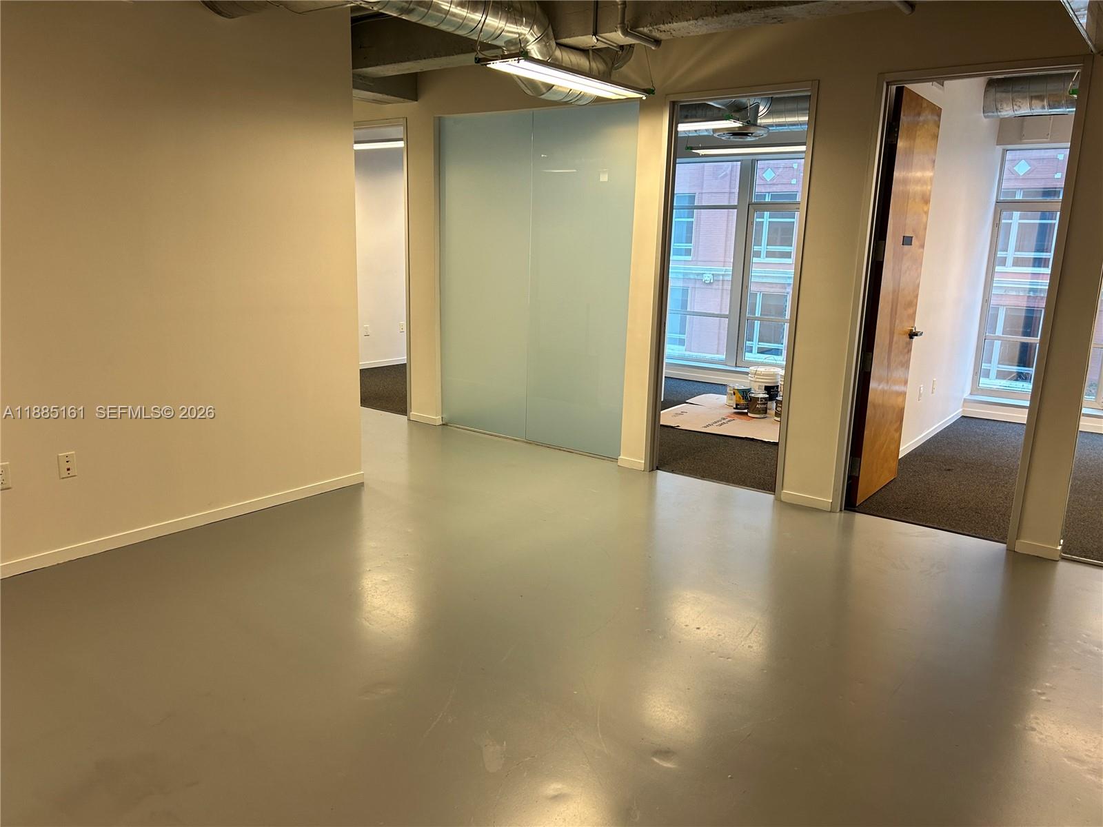 An office interior features gray flooring, a frosted glass partition, and an open doorway — 14 NE 1st Ave # 500D, Miami FL 33132, MIAMI, FL
