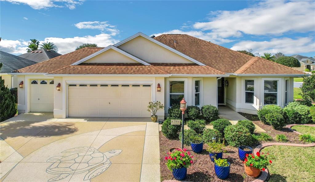 A single-story house with a tan exterior, a two-car garage, and a turtle-patterned driveway — 2946 DUKE TERRACE, THE VILLAGES, FL