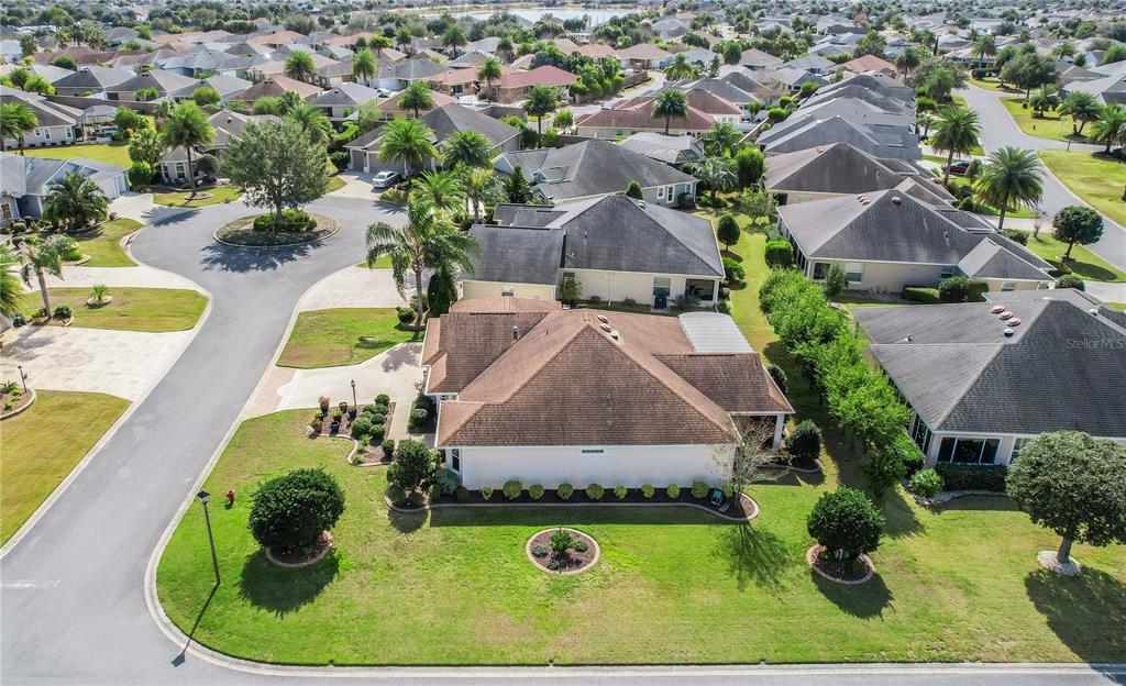 An aerial view shows a suburban house with a brown roof and a large lawn — 2946 DUKE TERRACE, THE VILLAGES, FL