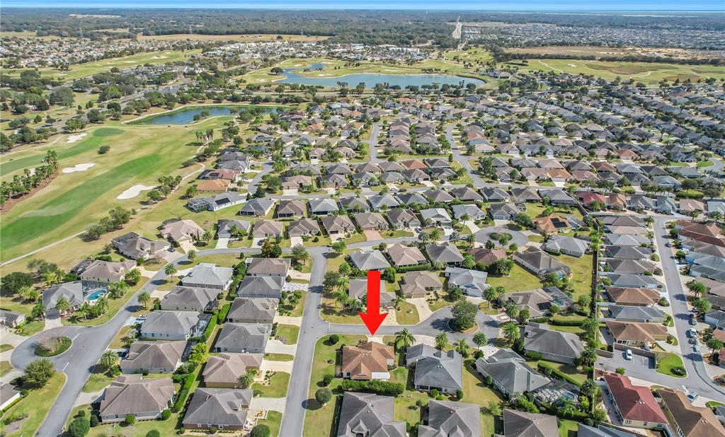 An aerial view shows a residential neighborhood with a red arrow pointing to a house — 2946 DUKE TERRACE, THE VILLAGES, FL