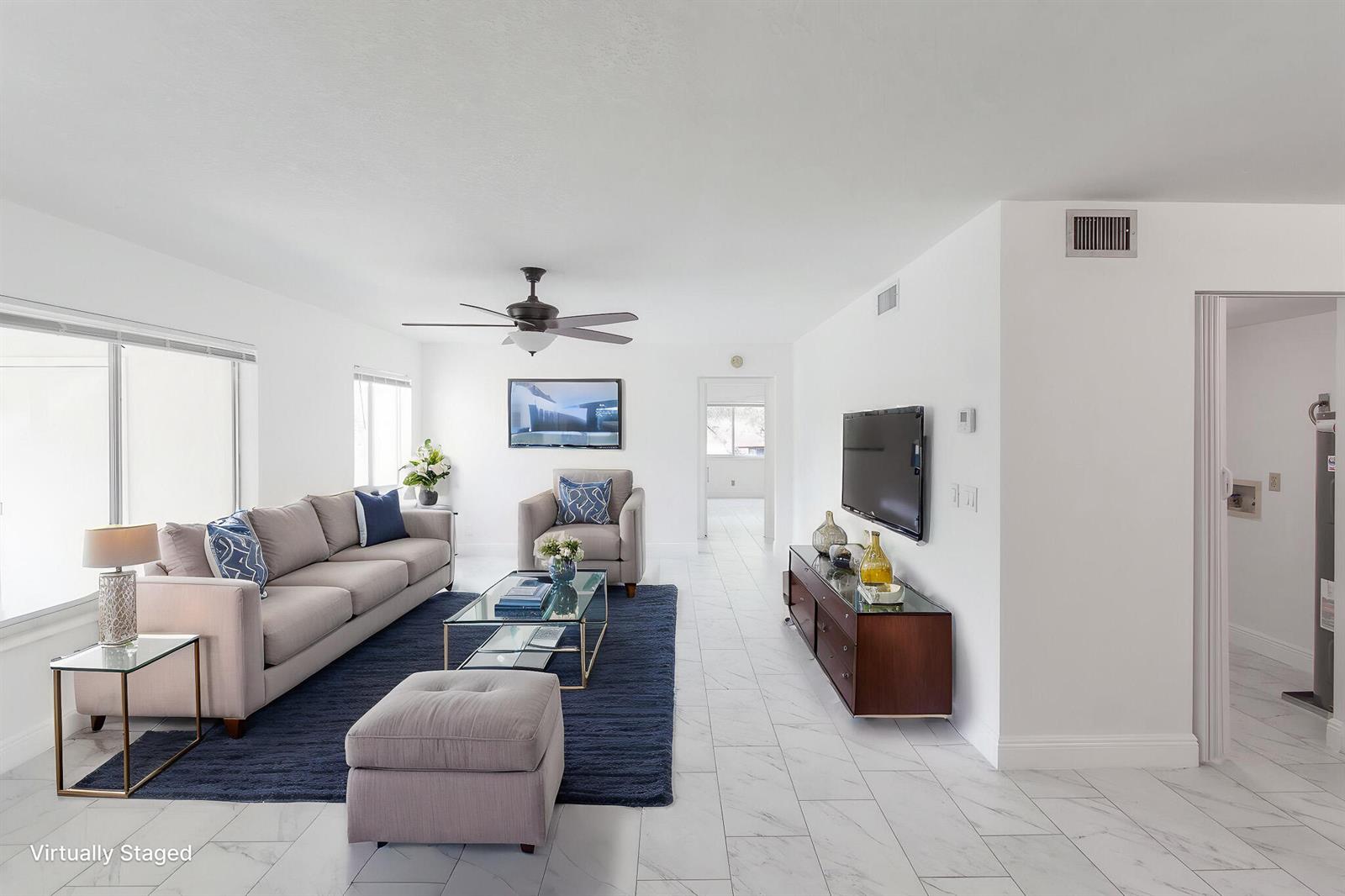 A living room with white walls, marble-look tile floors, a blue rug, and modern furniture — 4899 Sable Pine Circle # A2, West Palm Beach FL 33417, WEST PALM BEACH, FL