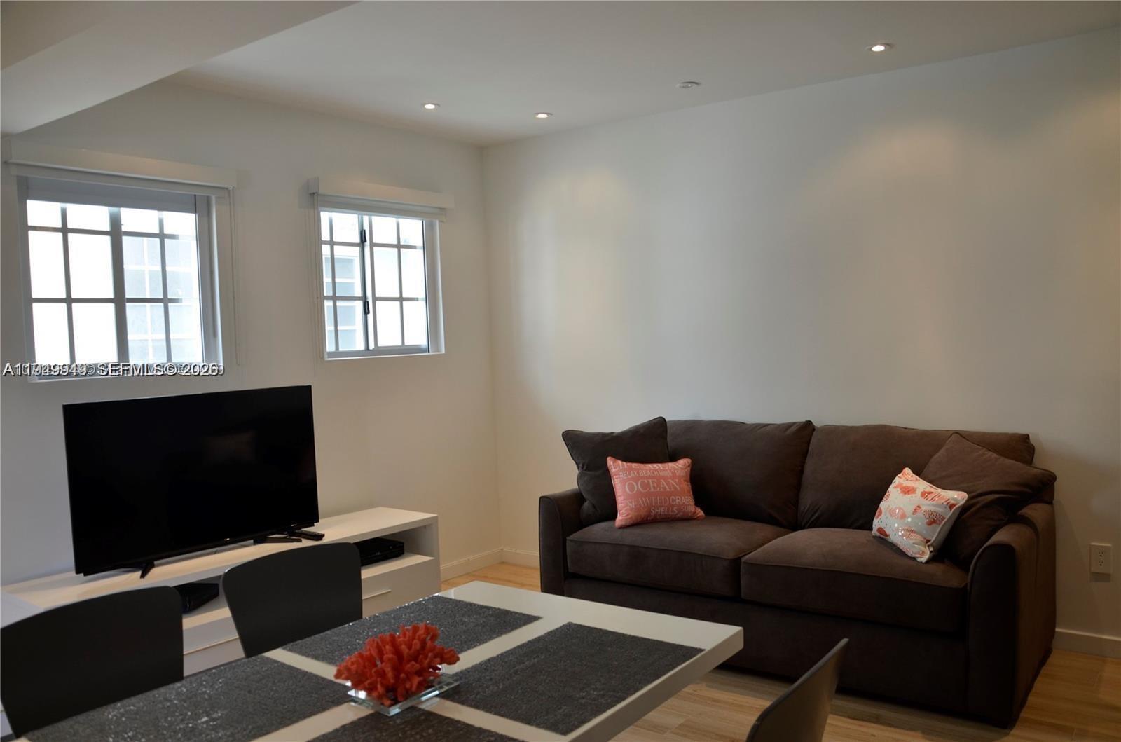 A living and dining area features a brown sofa, a television, and a dining table — 700 16th St # 201, Miami Beach FL 33139, MIAMI BEACH, FL