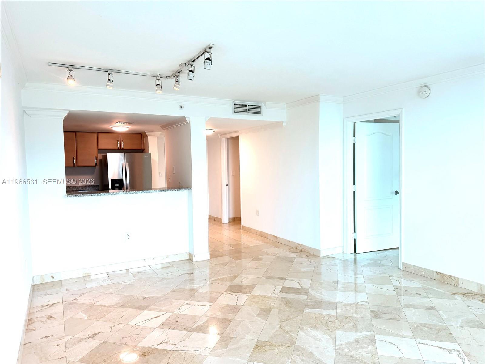 An interior view shows a living area with marble tile floors and an open kitchen — 2101 Brickell Ave # 2202, Miami FL 33129, MIAMI, FL