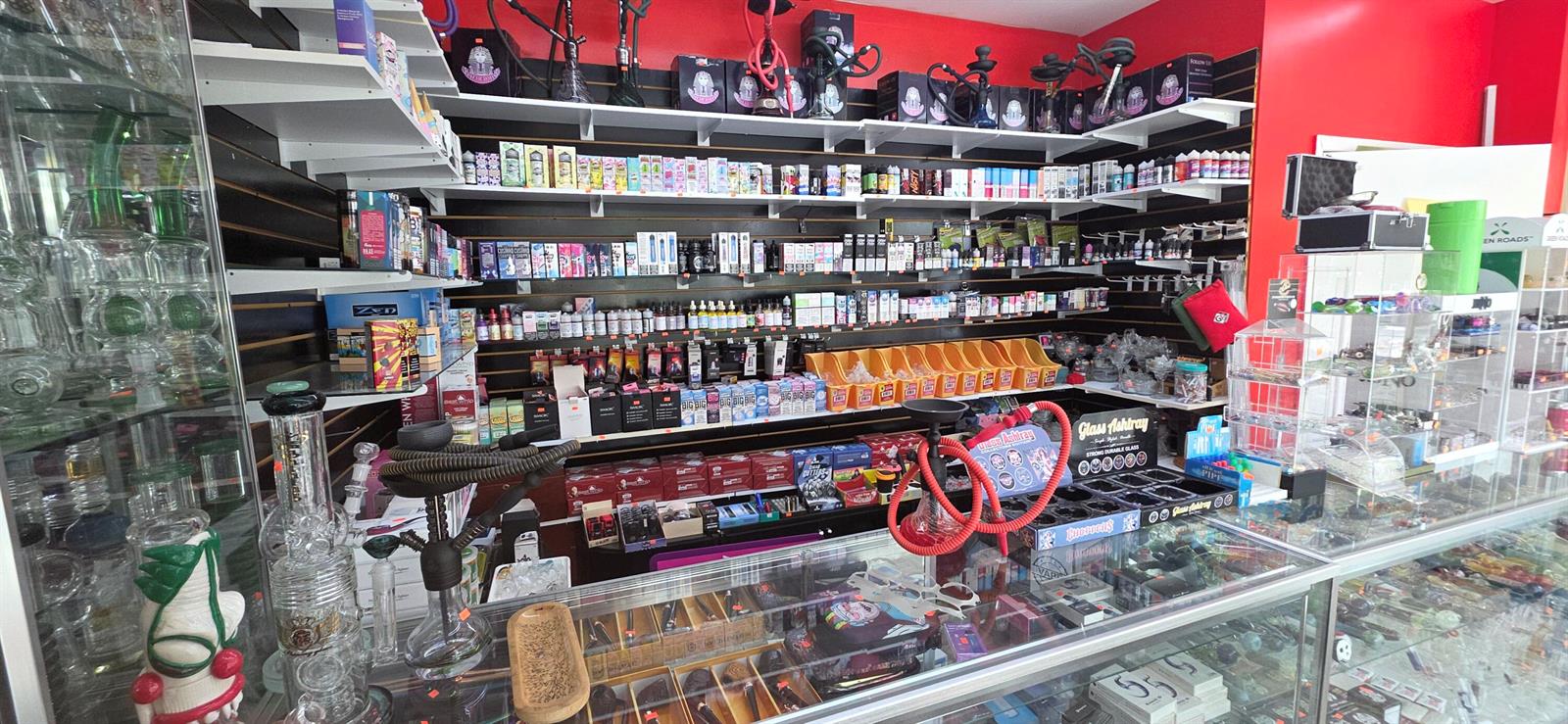 A retail shop interior features shelves stocked with vaping products, hookahs, and glass smoking accessories — 580 S Federal Highway, Pompano Beach FL 33062, POMPANO BEACH, FL