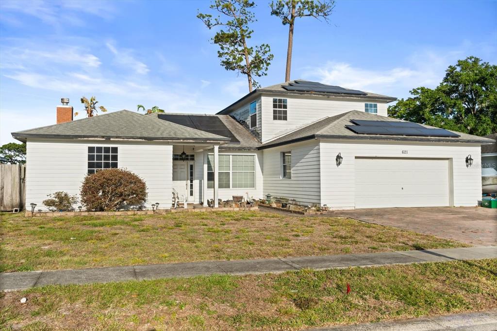 A two-story white house with solar panels on the roof and an attached garage — 621 PRAIRIE LANE, ALTAMONTE SPRINGS, FL